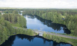 Ilmakuva Juupajoen Korkeakoskelta. Juna-rata ylittää Tehtaanjärven metsäisessä maisemassa Korkeakoskella.